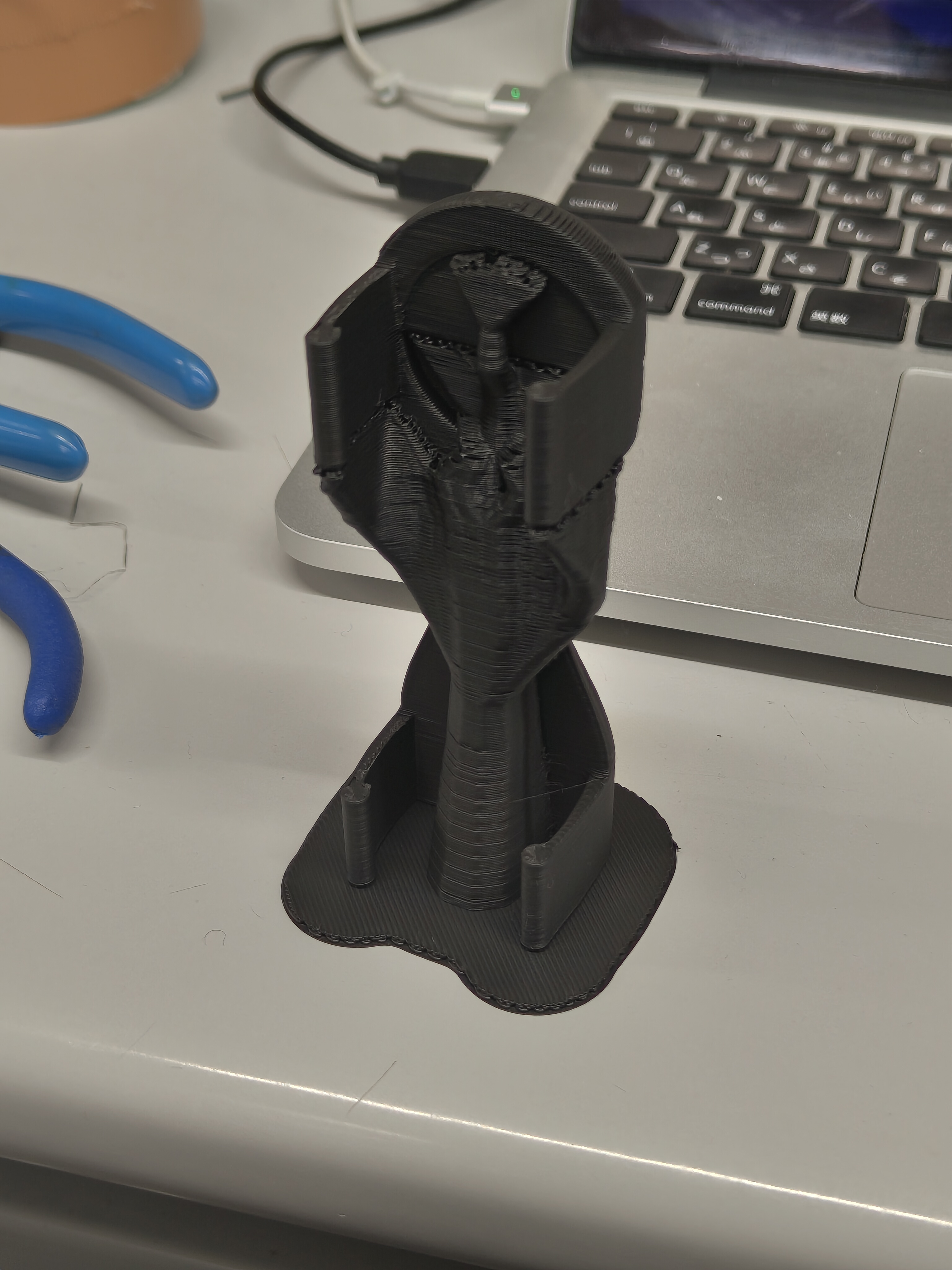 Photo of 3D printing. It is positioned vertically with the disc facing upwards.